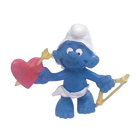 Blue Smurf figurine holding a red heart and bow and arrow on a white background